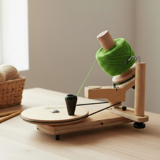 Fuzzy Goat Maple Jumbo Yarn Ball Winder made of solid wood with a green yarn cake on a light wooden table